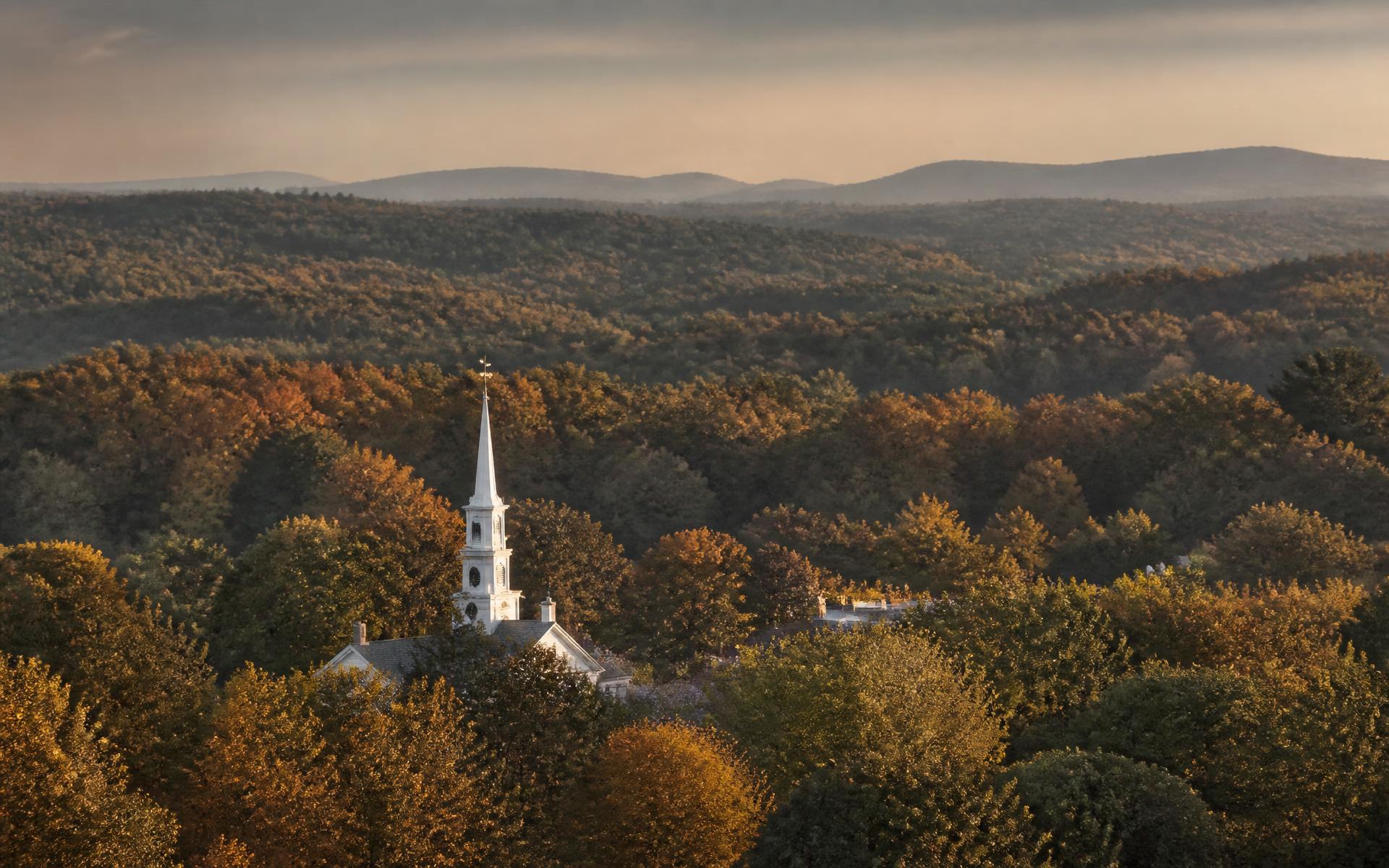 Rolling wooded hills of Morris County, New Jersey at golden hour with a colonial church steeple